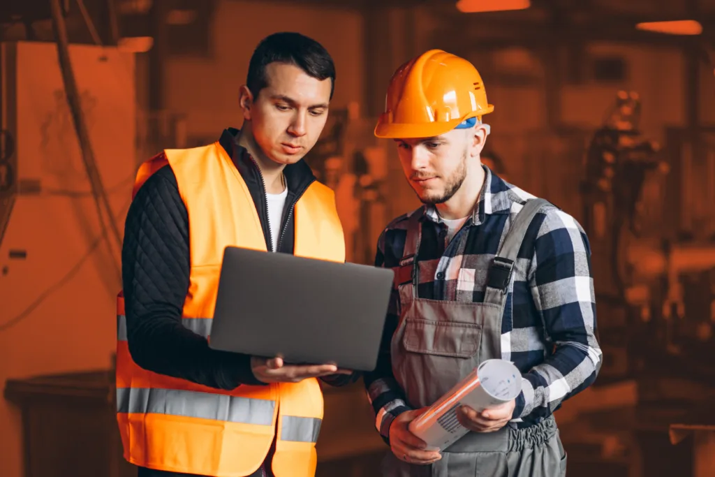 Deux intérimaires polonais travaillent dans une usine avec un ordinateur portable